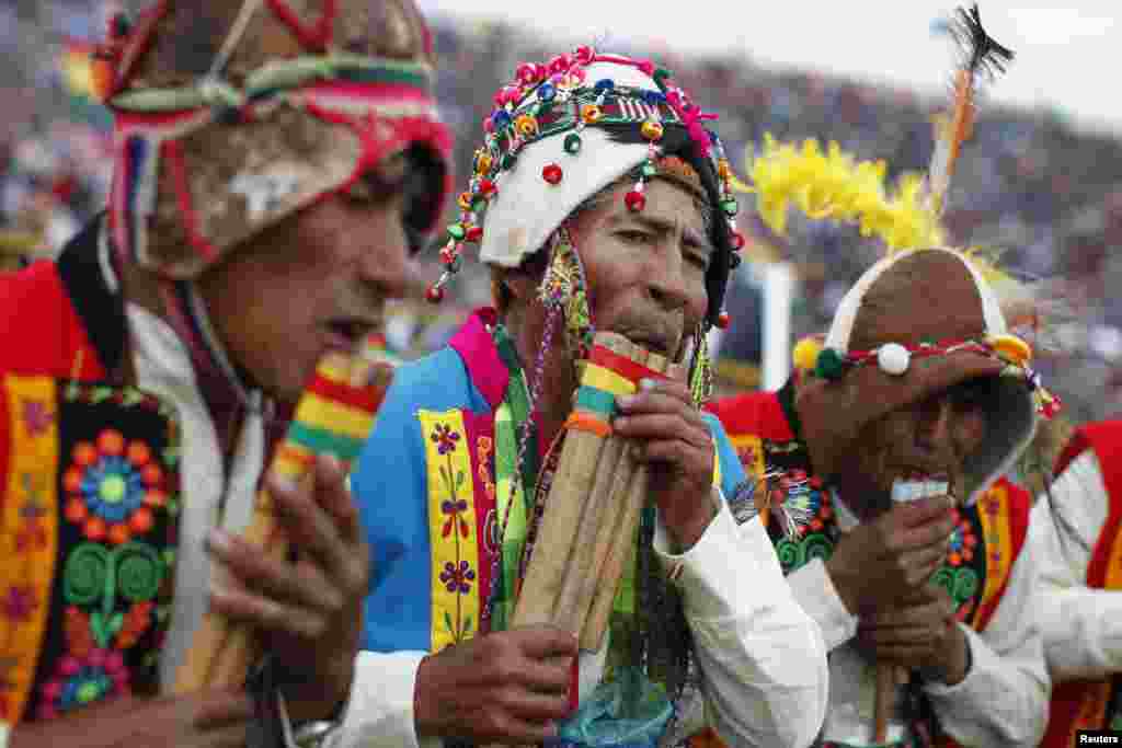 Indigenous men blow traditional flutes in Santa Cruz de la Sierra, Bolivia, June 14, 2014.