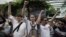 Supporters of anti-coup activists gather outside a police station, cheering them on and gesturing in Bangkok, June 24, 2015. 