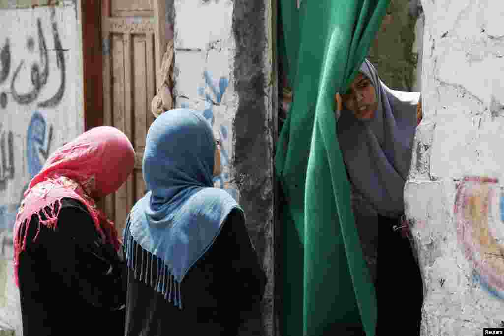 Palestinian women gather near the rubble of a building after what police said was an Israeli air strike at Shati refugee camp in Gaza City, August 4, 2014.