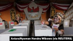 FILE - Petugas mengenakan pakaian adat Papua saat pelaksanaan Pemilu di sebuah TPS di Badung, Bali, 17 April 2019. (Foto: Antara/Nyoman Hendra Wibowo via Reuters)