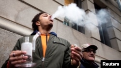 A man smokes as he waits in line for the opening of the Quebec Cannabis Society (SQDC) store, on the day Canada legalizes recreational marijuana, in Montreal, Quebec, Canada, Oct. 17, 2018. 