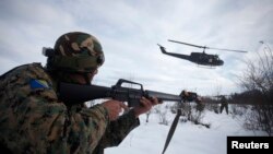 FILE - A soldier of the Armed Forces of Bosnia and Herzegovina (OSBIH) watches the departure of a helicopter during an exercise on the Manjaca mountain, near Banja Luka, Dec. 14, 2012.