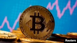FILE - A representation of virtual currency Bitcoin is seen in front of a stock graph in this illustration taken November 19, 2020. (REUTERS/Dado Ruvic/Illustration/File Photo)