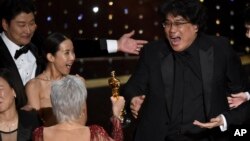 Bong Joon Ho, right, reacts as he is presented with the award for best picture for "Parasite" from presenter Jane Fonda at the Oscars on Sunday, Feb. 9, 2020, at the Dolby Theatre in Los Angeles. Looking on from left are Kang-Ho Song and Kwak Sin Ae.(AP P