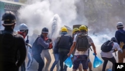 Pengunjuk rasa anti kudeta menggunakan alat pemadam kebakaran untuk mengurangi dampak gas air mata yang ditembakkan oleh polisi anti huru hara di Yangon, Myanmar, Selasa, 9 Maret 2021. (Foto: dok).