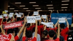 FILE - Hong Kong soccer fans turn their backs and boo the Chinese national anthem as they chant "Hong Kong is not China" during a World Cup qualifying soccer match between Hong Kong and Iran, in Hong Kong, Sept. 10, 2019. 