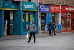 A man wearing a protective mask walks along a street following a local lockdown imposed amid the coronavirus disease (COVID-19) outbreak in Leicester, Britain, July 1, 2020.