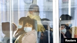 Passengers wear masks inside a trolley bus in Pyongyang, North Korea, Feb. 22, 2020, and released by Kyodo, Feb. 23, 2020.