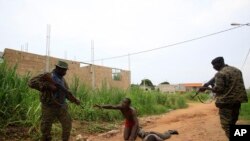 Les soldats des Forces républicaines capturent deux miliciens présumés dans le quartier Riviera I à Abidjan, Côte-d'Ivoire, 13 avril 2011. (AP Photo / Rebecca Blackwell)