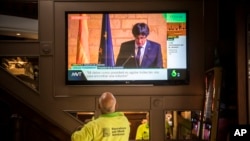 People in a bar watch the speech of Catalan regional president Carles Puigdemont on television in Barcelona, Spain, Oct. 26, 2017.