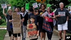 FILE - Jackson Borrello, 8, leads activists with a Tuesdays with Tillis rally outside U.S. Senator Tom Tillis' office at the Federal Building to demand the reunification of families separated at the border in Raleigh, N.C., June 26, 2018.