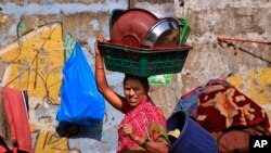 ស្រ្តី​ឥណ្ឌា​ម្នាក់​កំពុង​ទូល​គ្រឿង​ឆ្នាំងចាន​សម្រាប់​លក់​ នៅ​ថ្ងៃ​ទិវានារីអន្តរជាតិ នៅ​ទីក្រុង​មុមបៃ ប្រទេសឥណ្ឌា កាលពីថ្ងៃ៨ ខែមីនា​ ឆ្នាំ២០១៥។ 