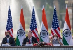 U.S. Secretary of State Mike Pompeo, center, speaks as Secretary of Defence Mark Esper, left, and Indian Defence Minister Rajnath Singh sit beside him during a joint press conference at Hyderabad House in New Delhi, India, Oct. 27, 2020.