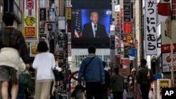A screen shows a broadcast of President-elect Joe Biden speaking, Nov. 8, 2020, at the Shinjuku shopping district in Tokyo, Japan.