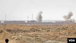 Seorang pemberontak mengamati serangan roket kubu Gaddafi di luar Ajdabiya, Libya, Selasa (12/4). Negara-negara NATO masih belum sepaham mengenai keterlibatan mereka di negara ini.