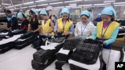 រូបឯកសារ៖ កម្មកររោងចក្រ​កម្ពុជា​បត់​សម្លៀកបំពាក់​ក្នុង​រោងចក្រ​មួយ ក្នុង​តំបន់​សេដ្ឋកិច្ច​ពិសេស​ នៅ​ជាយ​រាជធានី​ភ្នំពេញ កាល​ពី​ថ្ងៃ​ពុធ​ ទី​២៣ ខែសីហា ឆ្នាំ​២០១៧។ (AP Photo/Heng Sinith) 