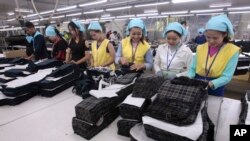 រូបឯកសារ៖ កម្មកររោងចក្រ​កម្ពុជា​បត់​សម្លៀកបំពាក់​ក្នុង​រោងចក្រ​មួយ ក្នុង​តំបន់​សេដ្ឋកិច្ច​ពិសេស​ នៅ​ជាយ​រាជធានី​ភ្នំពេញ កាល​ពី​ថ្ងៃ​ពុធ​ ទី​២៣ ខែសីហា ឆ្នាំ​២០១៧។ (AP Photo/Heng Sinith) 