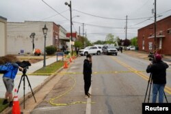 Anggota masyarakat dan media berdiri di dekat TKP, sehari setelah penembakan di pesta ulang tahun seorang remaja di sebuah studio tari, di Dadeville, Alabama, AS, 16 April 2023. (Foto: REUTERS/Cheney Orr)