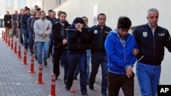 FILE - Police officers escort people, arrested because of suspected links to U.S.-based cleric Fethullah Gulen, in Kayseri, Turkey, April 26, 2017. Olay Duzgun/DHA-Depo Photos via AP)
