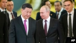 FILE - Russian President Vladimir Putin, right, and Chinese President Xi Jinping enter a hall for the talks in the Kremlin in Moscow, Russia, June 5, 2019. 