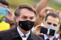 FILE - Brazil's President Jair Bolsonaro leaves his official residence of Alvorada palace in Brasilia, May 25, 2020.