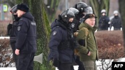 Police officers detain a man as people come to a monument to the victims of Soviet political repressions to lay flowers for late Russian opposition leader Alexei Navalny in St. Petersburg on Feb. 17, 2024, one day after the death of Navalny in an Arctic prison.