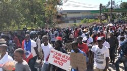 Protester holds sign that says « Mrs La Lime, Ambassador Sison stop supporting dictator. (VOA/Matiado Vilme)