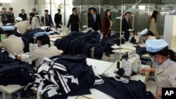 지난해 10월 한국 국회의원들이 개성공단을 현지 시찰하는 가운데, 개성공단 북한 노동자들이 작업에 열중하고 있다.