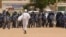 Anti-government protestor faces riot police last week in Khartoum. (A. Ahmed/VOA)