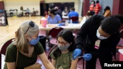 Pearl Werner (13) divaksinasi COVID-19 di sebuah klinik Departemen Kesehatan Masyarakat Philadelphia di Philadelphia, Pennsylvania, 18 Mei 2021. (REUTERS/Hannah Beier)