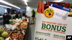 FILE - A sign advertises food stamp-related services at a farmer's market in Topsham, Maine, March 17, 2017.