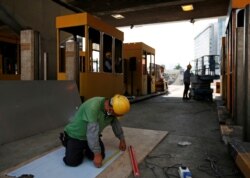 A worker repairs toll booths that were damaged during protests, at the Cross Harbour Tunnel near Hong Kong Polytechnic University in Hong Kong, Nov, 23, 2019.