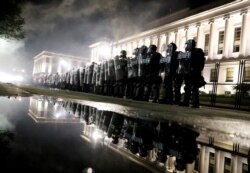 Law enforcement officers guard during a protest following the police shooting of Jacob Blake, a Black man, in Kenosha, Wisconsin, Aug. 25, 2020.