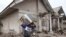 A man carries a television as he evacuates to a safer place following the eruption of Mount Semeru in Lumajang district, East Java province, Indonesia, Dec. 6, 2021. 