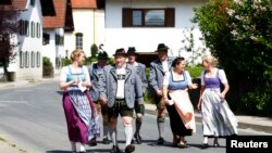 People in traditional clothes arrive to cast their vote for the European Parliament elections in Haunshofen near Starnberg, Germany, May 25, 2014. 
