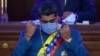 Venezuelan President Nicolás Maduro removes his mask as he prepares to speak about his annual report to the nation before legislators in the National Assembly, Caracas, Jan. 12, 2021.