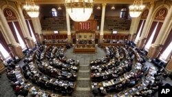 FILE - State representatives work in the Iowa House on the opening day of the Iowa Legislature at the Statehouse in Des Moines, Iowa, Jan. 13, 2014. 