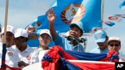 In this Friday, June 2, 2017, file photo, Cambodian Prime Minister Hun Sen, center, of the Cambodian People's Party (CPP), waves from a truck as he leads a rally in Phnom Penh, Cambodia, during the last day of campaigning ahead of the June 4 communal elections. (AP Photo/Heng Sinith)