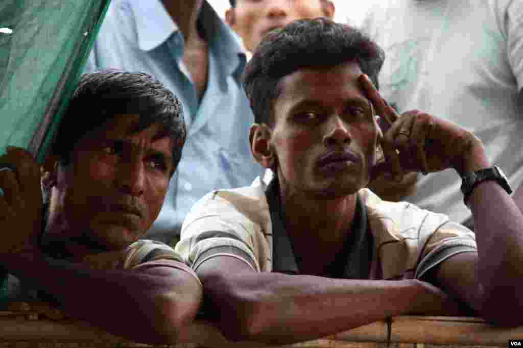 Muslim men look through the window of a food aid tent at Thet Kae Pyin Camp, outside Sittwe, Rakhine state, Burma, November, 2012. (D. Schearf/VOA)