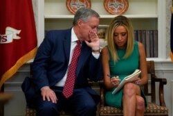 FILE - White House chief of staff Mark Meadows speaks with White House press secretary Kayleigh McEnany in the Oval Office of the White House, April 29, 2020, in Washington.