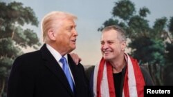Presiden Amerika Serikat Donald Trump menyambut guru sekolah Amerika Marc Fogel di Gedung Putih di Washington, D.C., 11 Februari 2025. (Kevin Lamarque/REUTERS)
