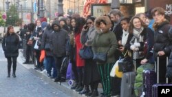 Commuters and tourists wait for a bus at Gare du Nord train station in Paris, Dec. 18, 2019. 