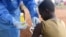 FILE - A Congolese health worker administers Ebola vaccine to a boy who had contact with an Ebola sufferer in the village of Mangina in North Kivu province of the Democratic Republic of Congo, Aug.18, 2018. 