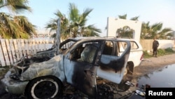 FILE - The day after the deaths, a person looks at a vehicle where seven aid workers with World Central Kitchen were killed in an Israeli airstrike in the Gaza Strip on April 1, 2024.