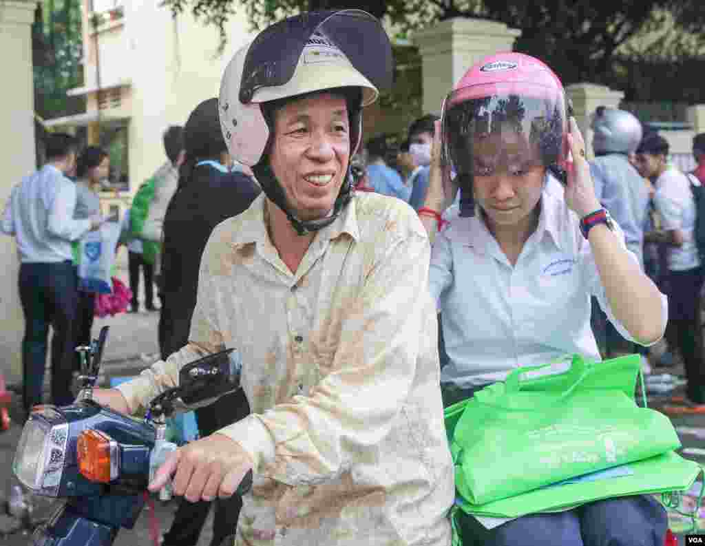 ឪពុក​របស់​បេក្ខជន​ប្រឡង​បាក់ឌុប ឌុបកូនស្រី​របស់ខ្លួន​​ចេញពី​មណ្ឌល​ប្រឡង​ថ្ងៃ​ចុងក្រោយ​នៅ​វិទ្យាល័យ​ព្រះ​យុគន្ធ នៅ​ថ្ងៃ​អង្គារ ទី​២៣ ខែសីហា ឆ្នាំ​២០១៦ នៅ​រាជធានី​ភ្នំពេញ។​ (ឡេង ឡែន/VOA)