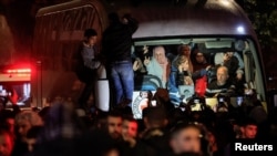 Para tahanan Palestina tiba dengan bus setelah dibebaskan dari penjara Israel sebagai bagian dari pertukaran sandera-tahanan dan kesepakatan gencatan senjata di Gaza antara Hamas dan Israel, di Ramallah, Tepi Barat, Senin dini hari, 20 Januari 2024. 