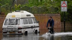 Seorang pria tampak menerjang banjir yang melanda London dengan sepedanya pada 28 April 2021. (Foto: Reuters/Toby Melville)
