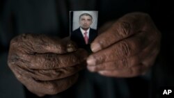 Ghanim Ahmed holds the photo of his son Ghazwan Ahmed, who was taken by unidentified gunmen after their village was liberated from Islamic State militants, in Bijwaniya village, south of Mosul, Iraq, Nov. 12, 2017.