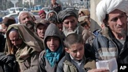 Warga Afghanistan antri untuk menerima pembagian gandum yang didistribusikan oleh Program Pangan PBB (WFP) di Kabul (foto: ilustrasi). 