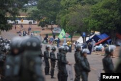 Pasukan keamanan Brazil melakukan penjagaan ketat, sementara para pendukung mantan Presiden Jair Bolsonaro meninggalkan perkemahan mereka di depan Markas Besar Angkatan Darat di Brasilia, 9 Januari 2023.